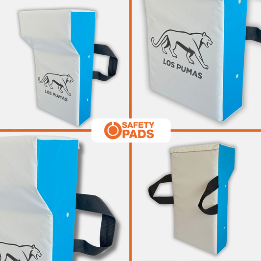 Four views of a Los Pumas safety pad on a light gray background, showing white and blue padded panels with black handles and a black panther logo. A central label reads 'SAFETY PADS'.