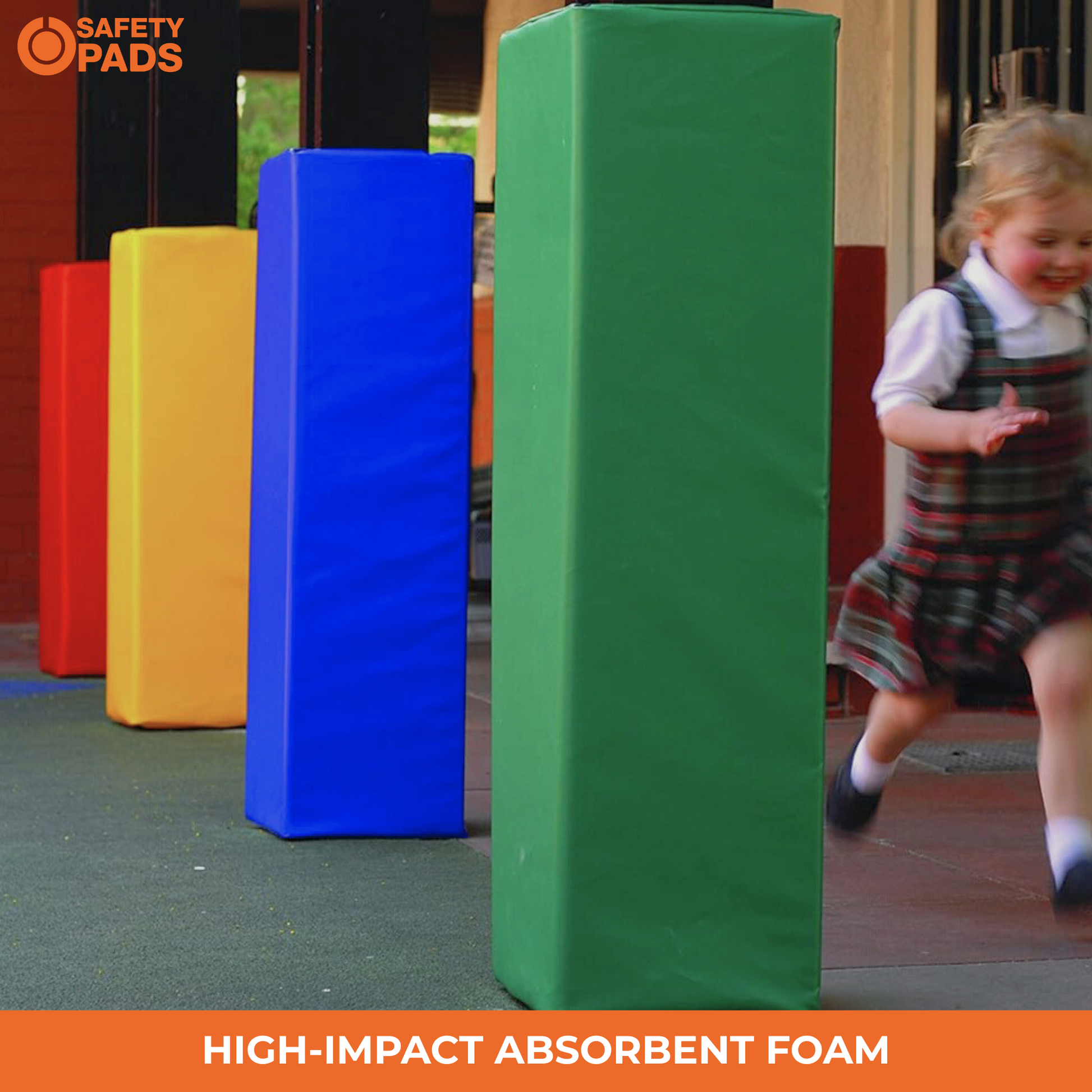 A young child runs past a set of colorful high-impact absorbent foam safety barriers, including a prominent green one in the foreground, with red, yellow, and blue barriers visible behind them.
