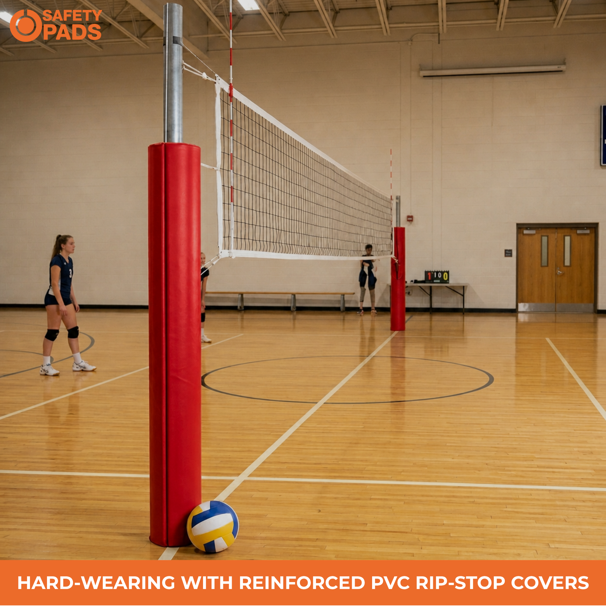 Red padded volleyball court stands with reinforced PVC rip-stop covers on a wooden indoor court, with players visible in the background and a Safety Pads logo in the top left.