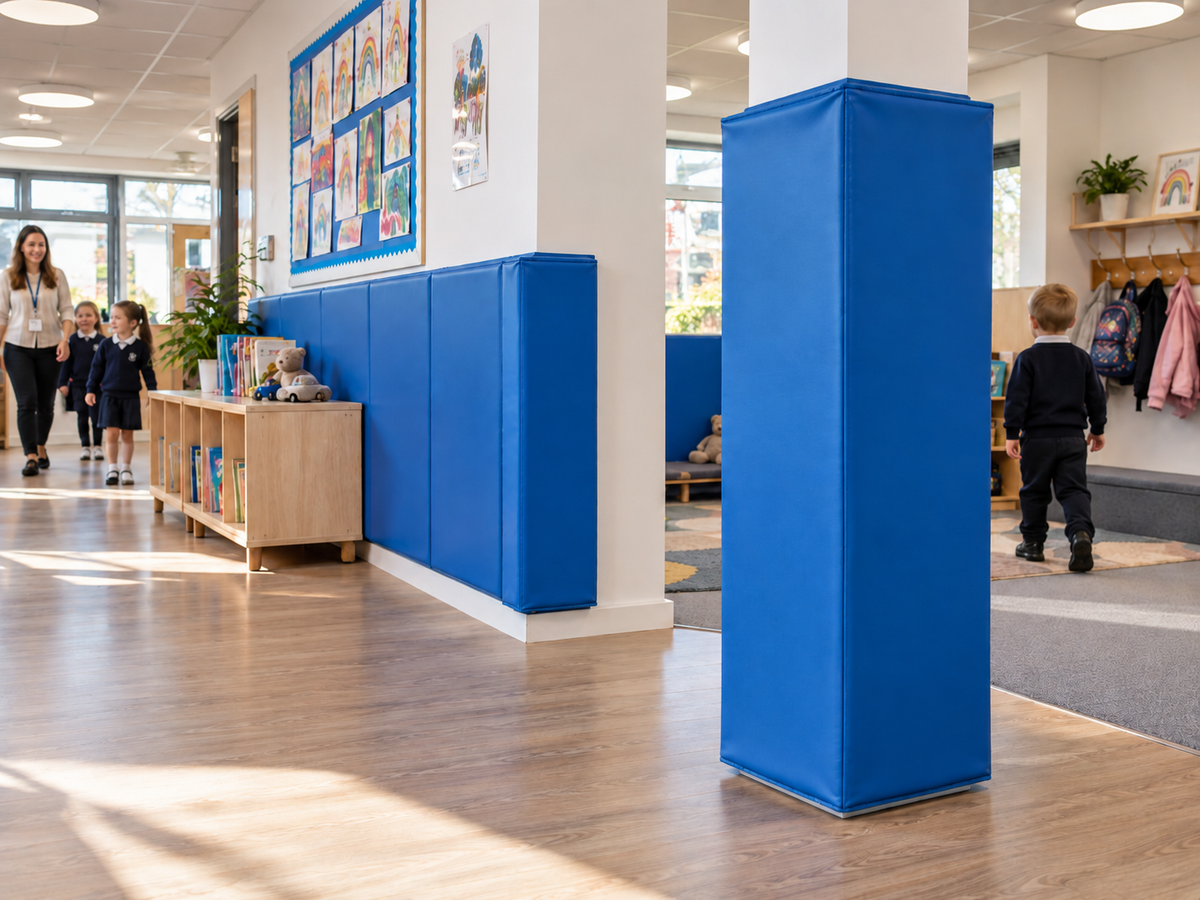 Blue safety wall pads and a padded column protector installed in a school or nursery corridor to help protect children from hard surfaces.