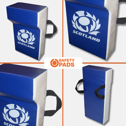 Blue and white Scotland rugby safety pads shown from multiple angles, featuring a white Scotland rose logo and black carrying handles on a light gray background with a central 'SAFETY PADS' logo.