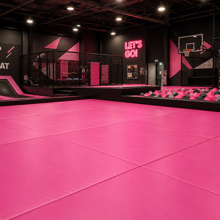 Pink trampoline park with 'Let's Go!' sign and basketball hoop.
